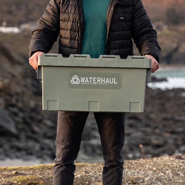Person holding a green box with 'Waterhaul' logo against a natural background