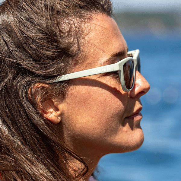 Woman wearing sunglasses with a blurred blue background