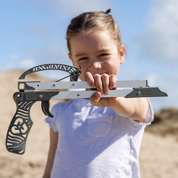 Child holding up a litter picker with a green recycled handle