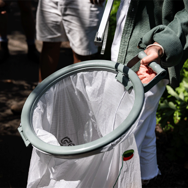 Person holding a circular litter picking bag hoop with a blurred background