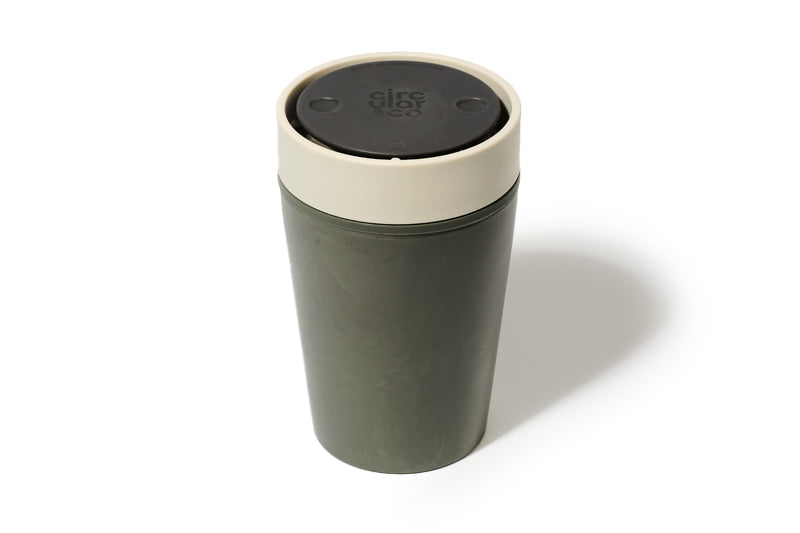 Green travel mug with beige lid on a white background
