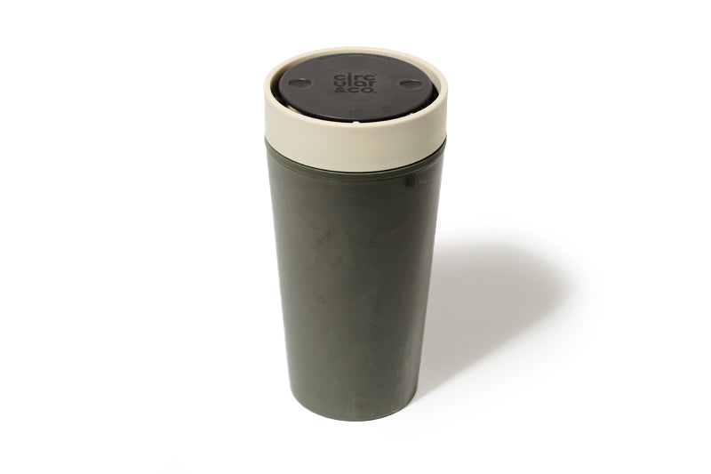 Green travel mug with beige lid on a white background