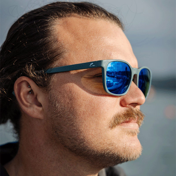 Man wearing sunglasses with Dolphin Project branding with a blurred background